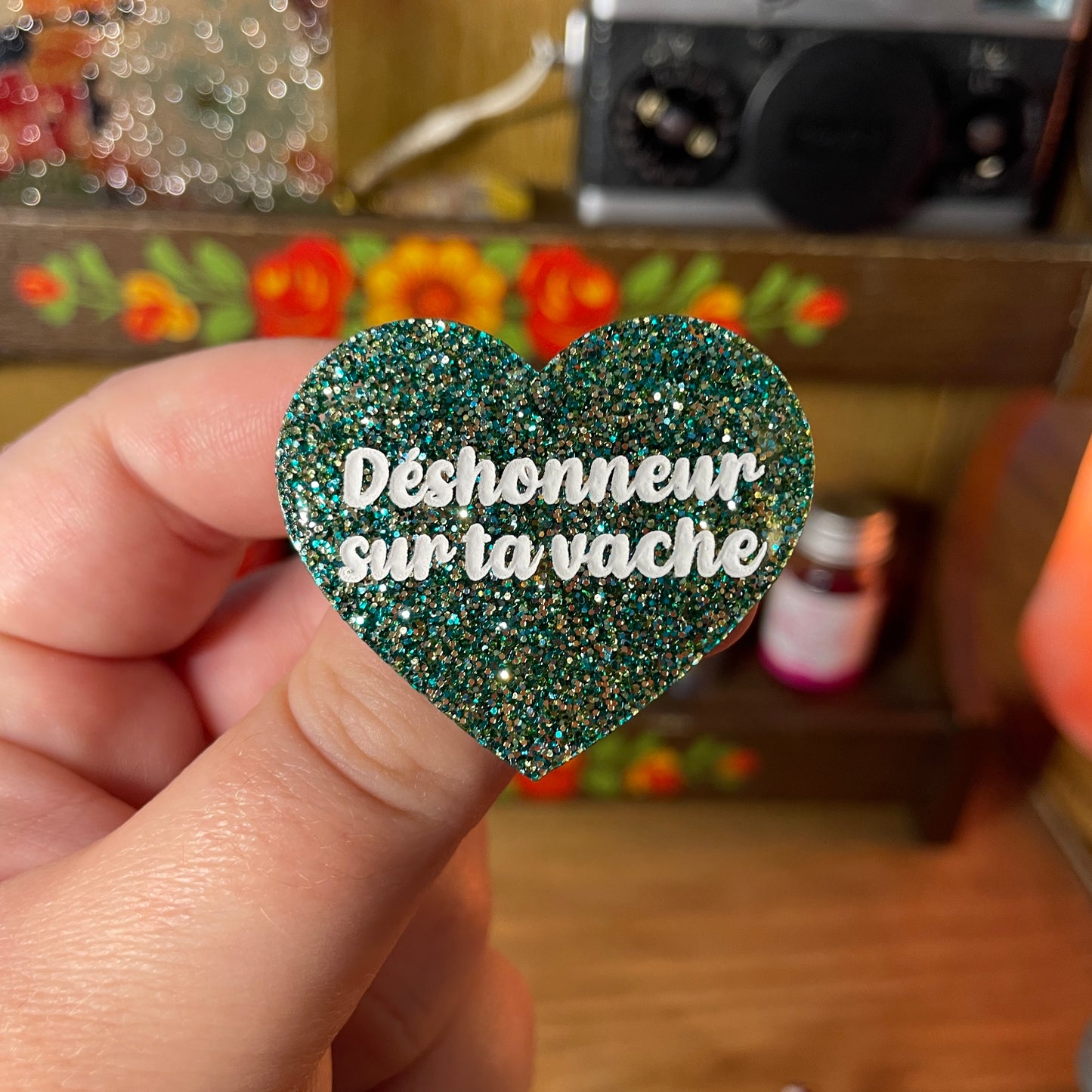 Broche "Déshonneur sur ta vache" en acrylique à paillettes vertes