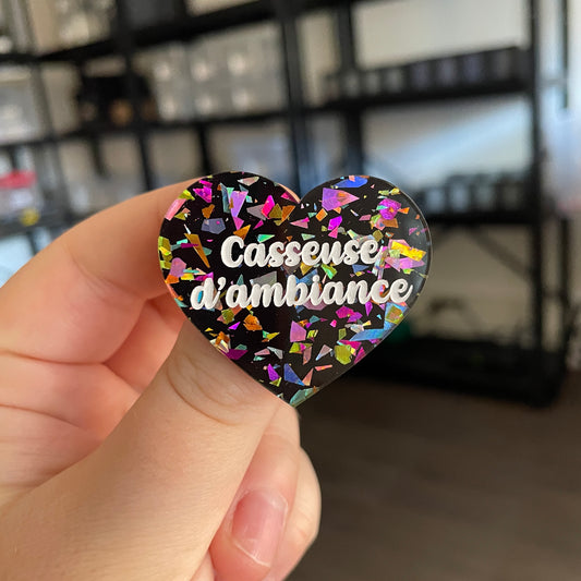 Broche "Casseuse d'ambiance" en acrylique noire avec des éclats de confettis multicolores