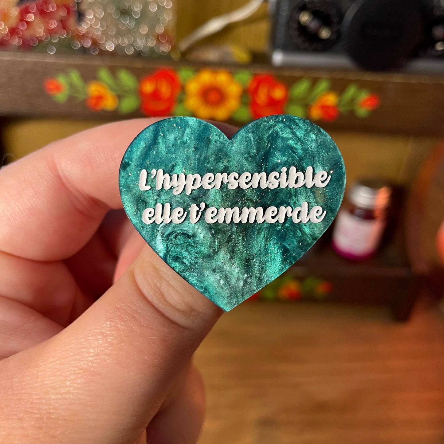 Broche "L'hypersensible elle t'emmerde" en acrylique marbrée verte et noire à paillettes