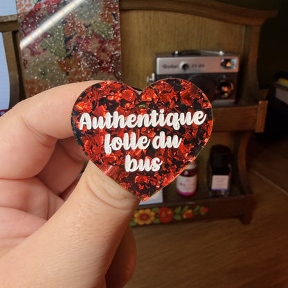 Broche "Authentique folle du bus" en acrylique noire avec des éclats de confettis rouges