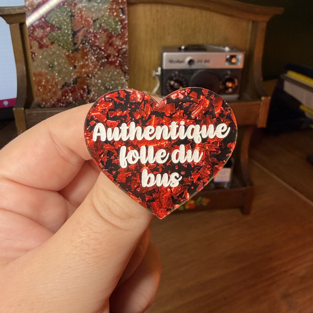 Broche "Authentique folle du bus" en acrylique noire avec des éclats de confettis rouges