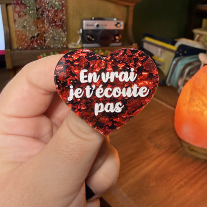 Broche "En vrai je t'écoute pas" en acrylique noire avec des éclats de confettis rouges