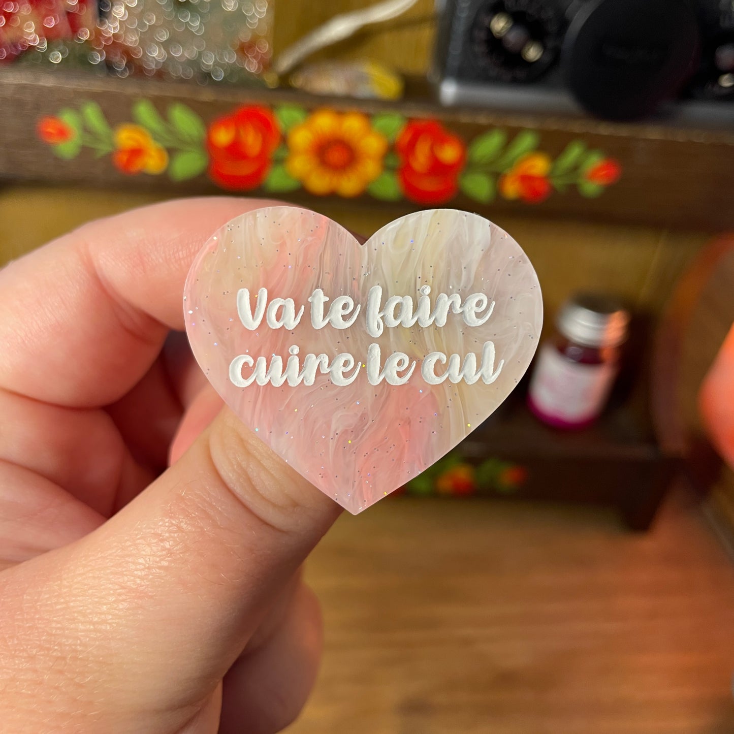 Broche "Va te faire cuire le cul" en acrylique semi transparente marbrée corail, jaune et blanche à paillettes