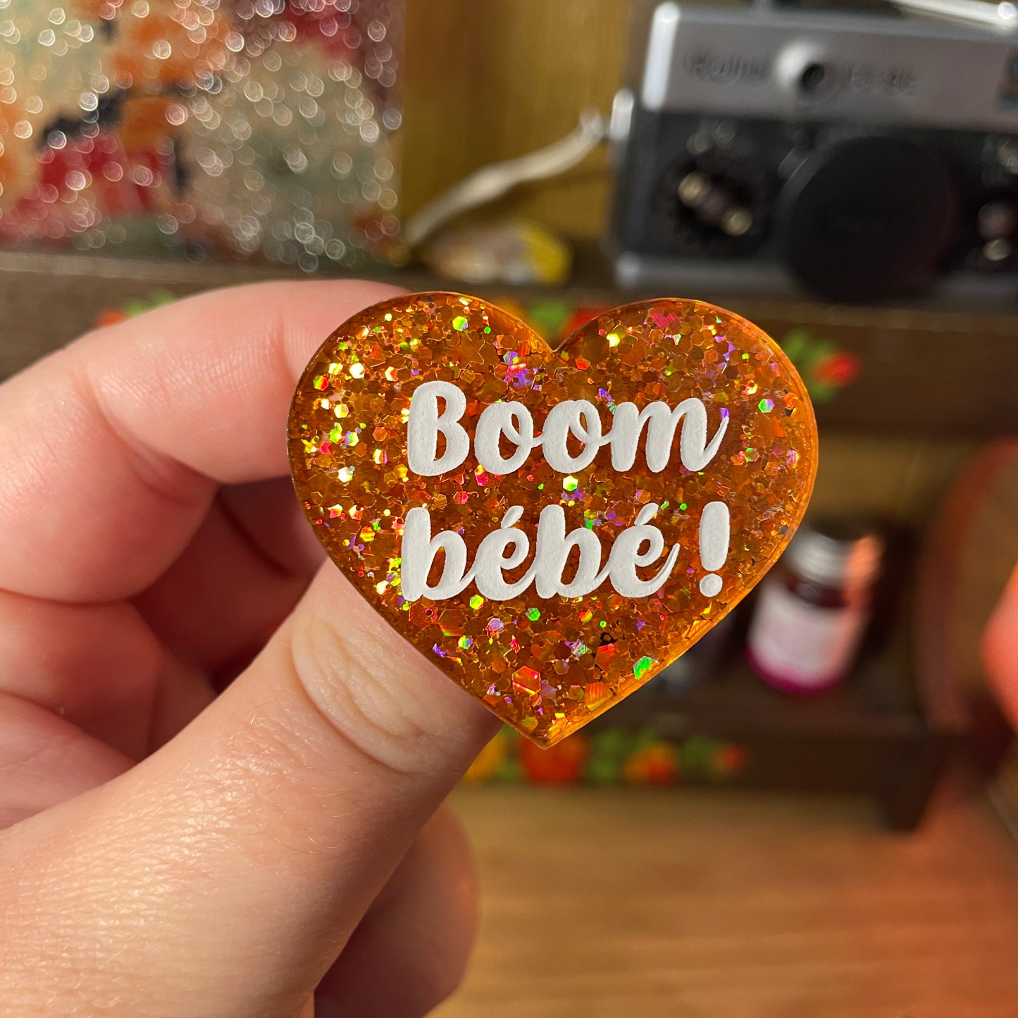 Broche "Boom bébé !" en acrylique semi transparente à paillettes oranges
