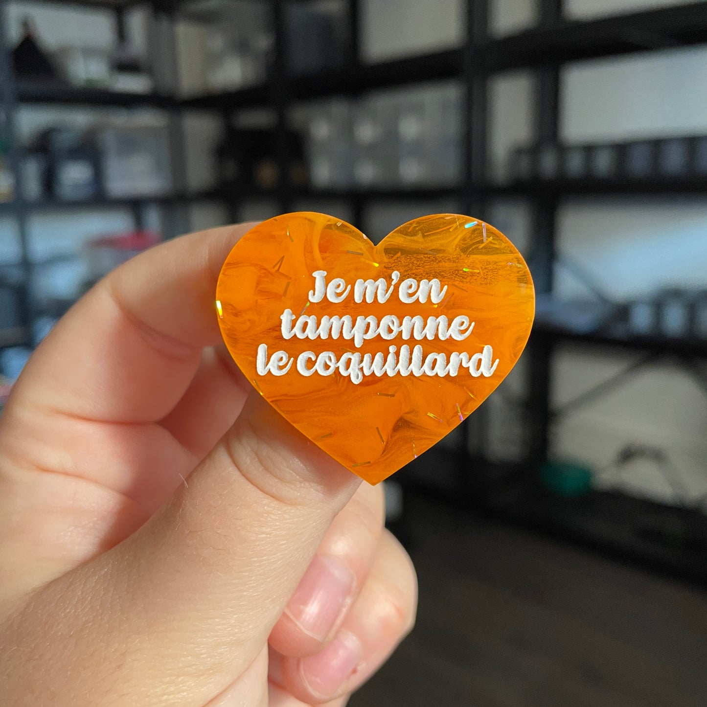 Broche "Je m'en tamponne le coquillard" en acrylique japonaise semi transparente orange avec des confettis