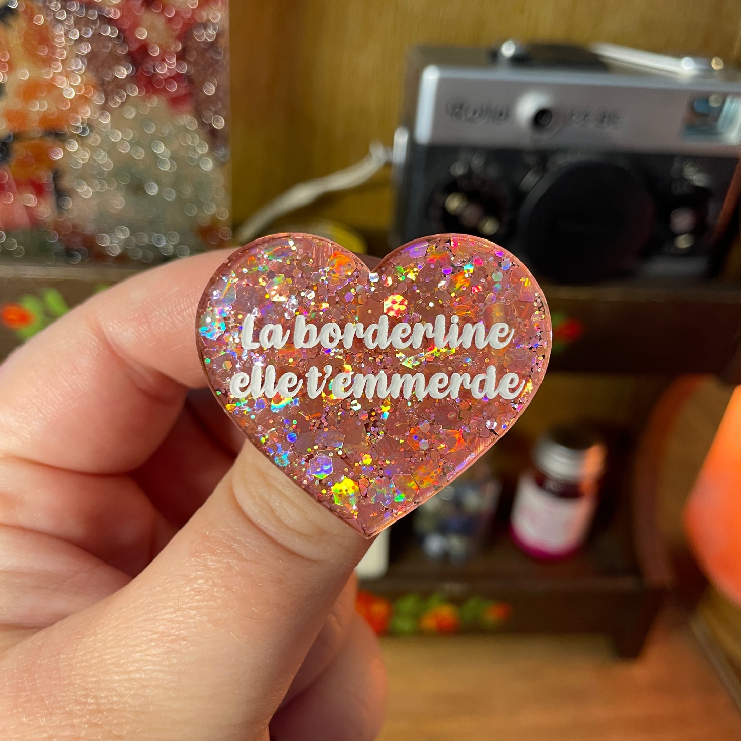 Broche "La borderline elle t'emmerde" en acrylique semi transparente à paillettes corail