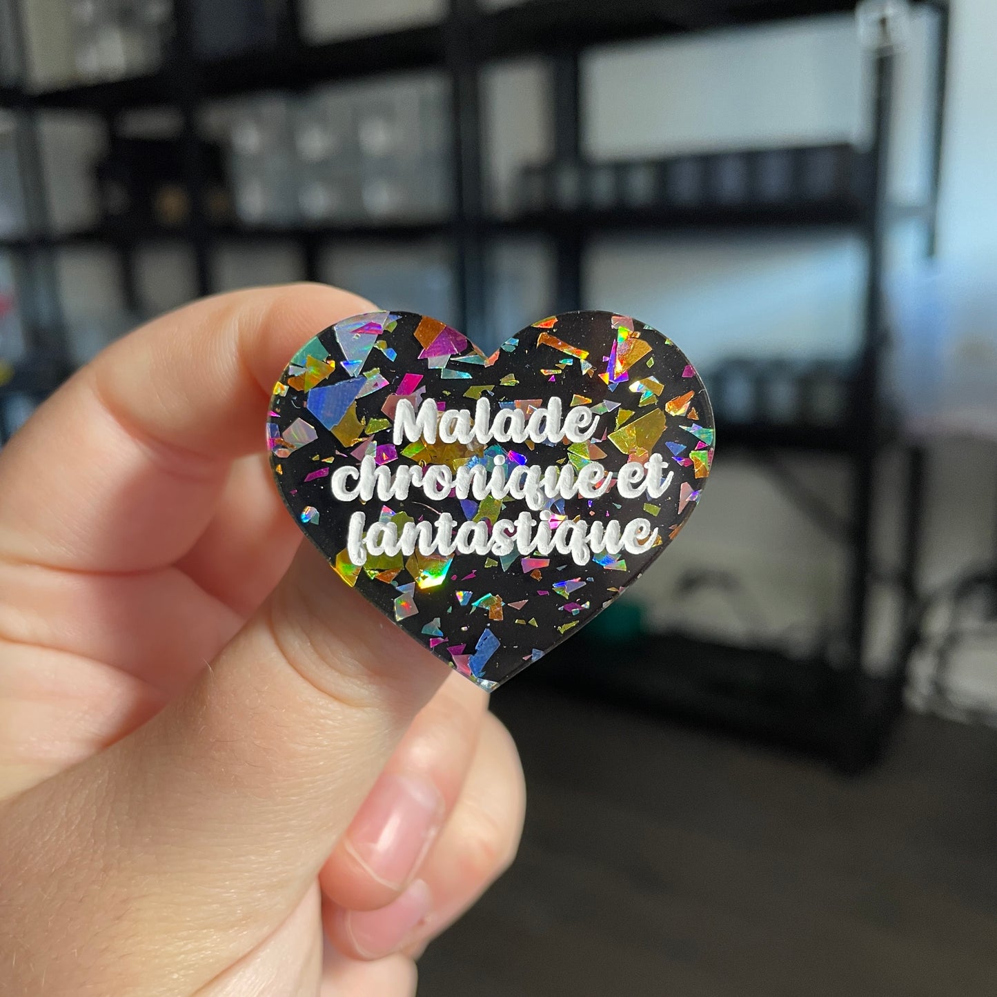 Broche "Malade chronique et fantastique" en acrylique noire avec des éclats de confettis multicolores