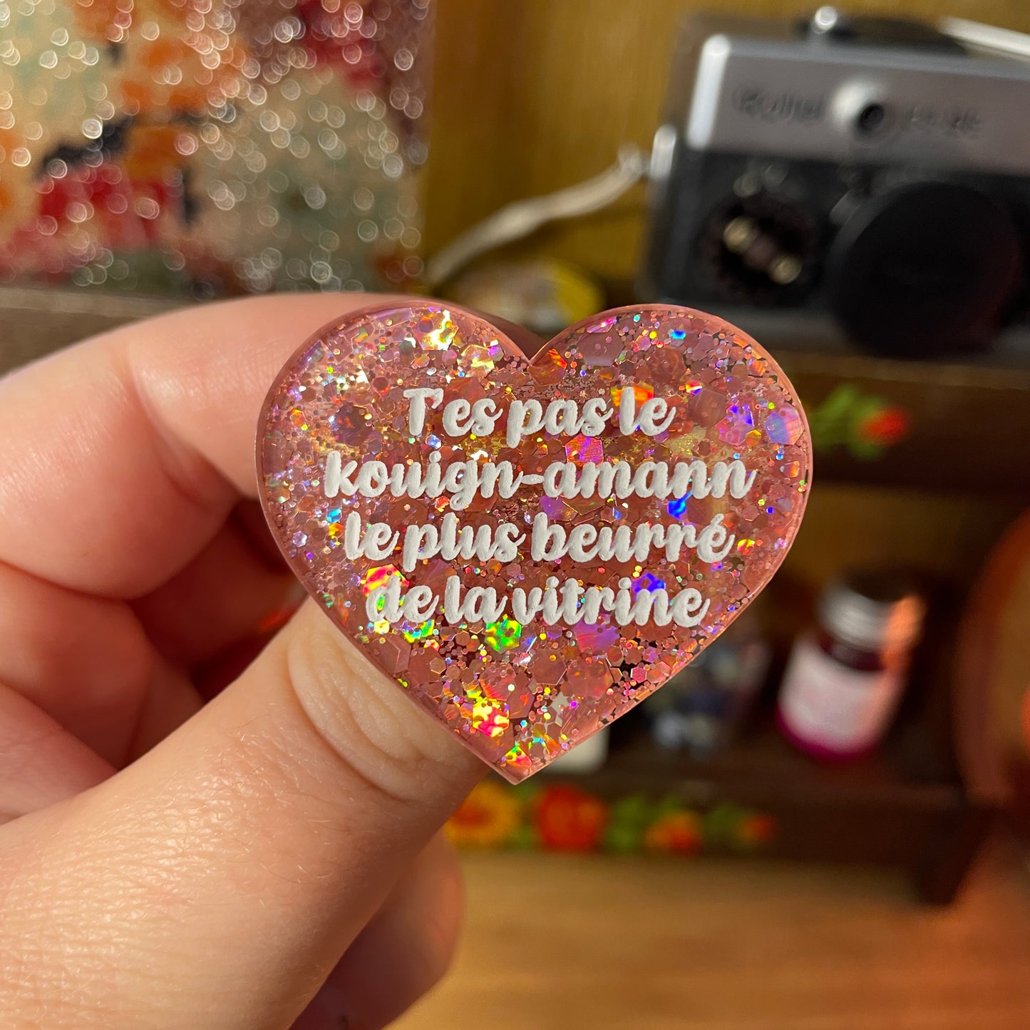 Broche "T'es pas le kouign-amann le plus beurré de la vitrine" en acrylique semi transparente à paillettes corail