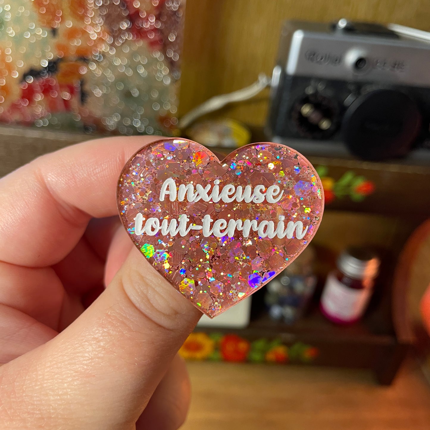 Broche "Anxieuse tout-terrain" en acrylique semi transparente à paillettes corail