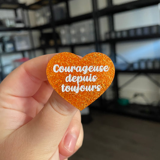 Broche "Courageuse depuis toujours" en acrylique à paillettes oranges