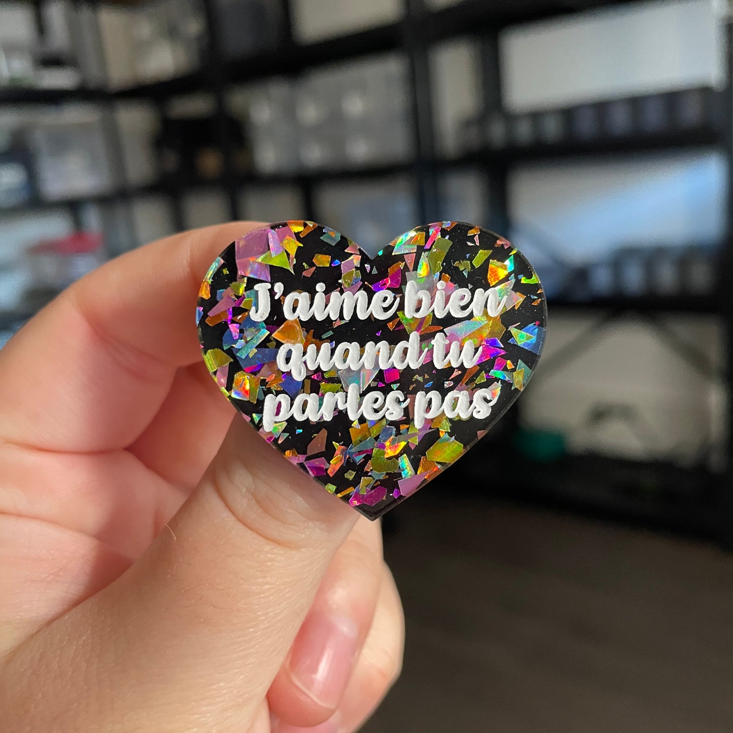 Broche "J'aime bien quand tu parles pas" en acrylique noire avec des éclats de confettis multicolores
