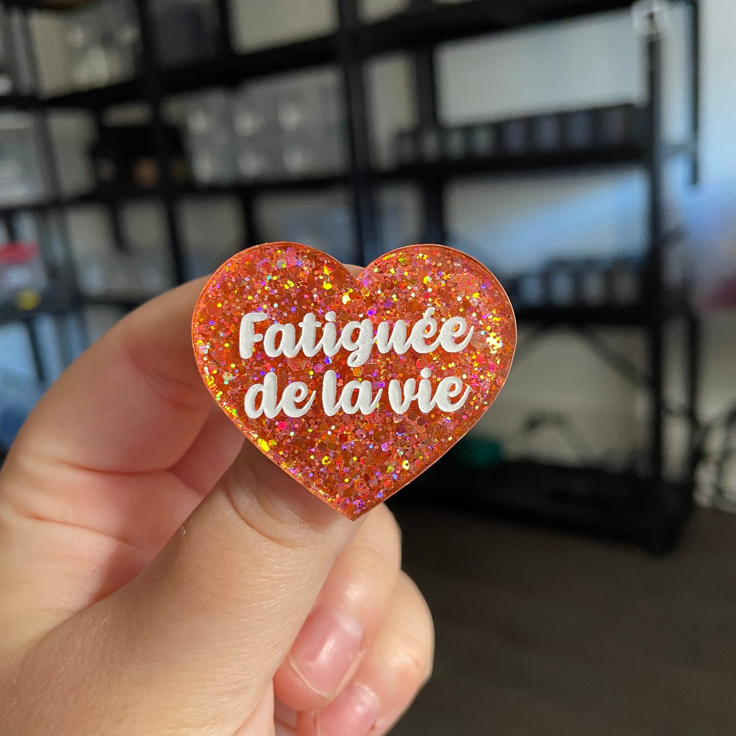Broche "Fatiguée de la vie" en acrylique semi transparente avec des paillettes corail