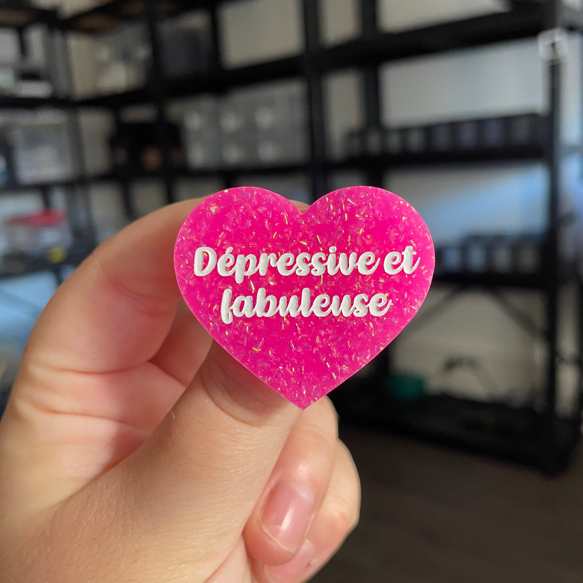 Broche "Dépressive et fabuleuse" en acrylique rose avec des paillettes