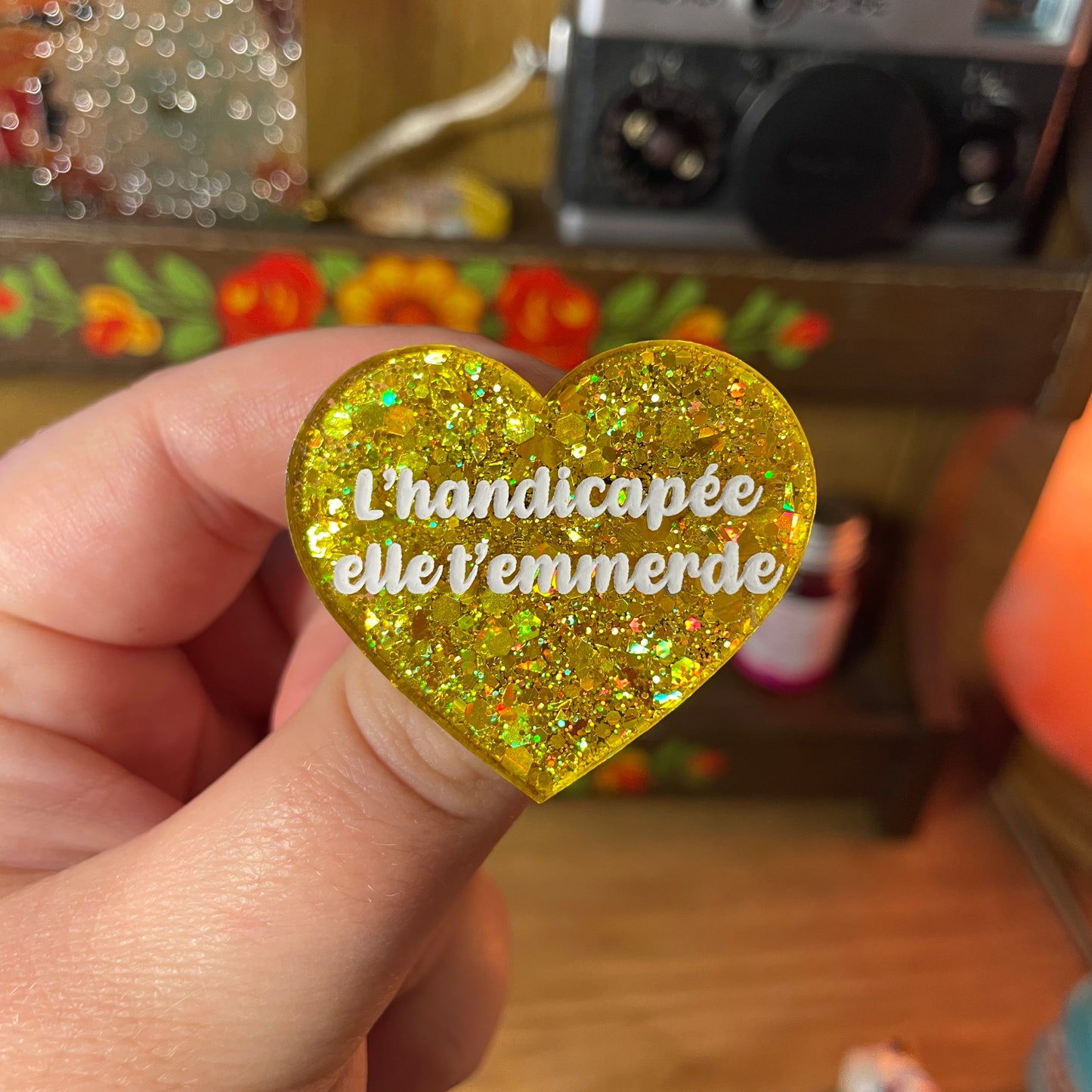 Broche "L'handicapée elle t'emmerde" en acrylique semi transparente à paillettes jaunes