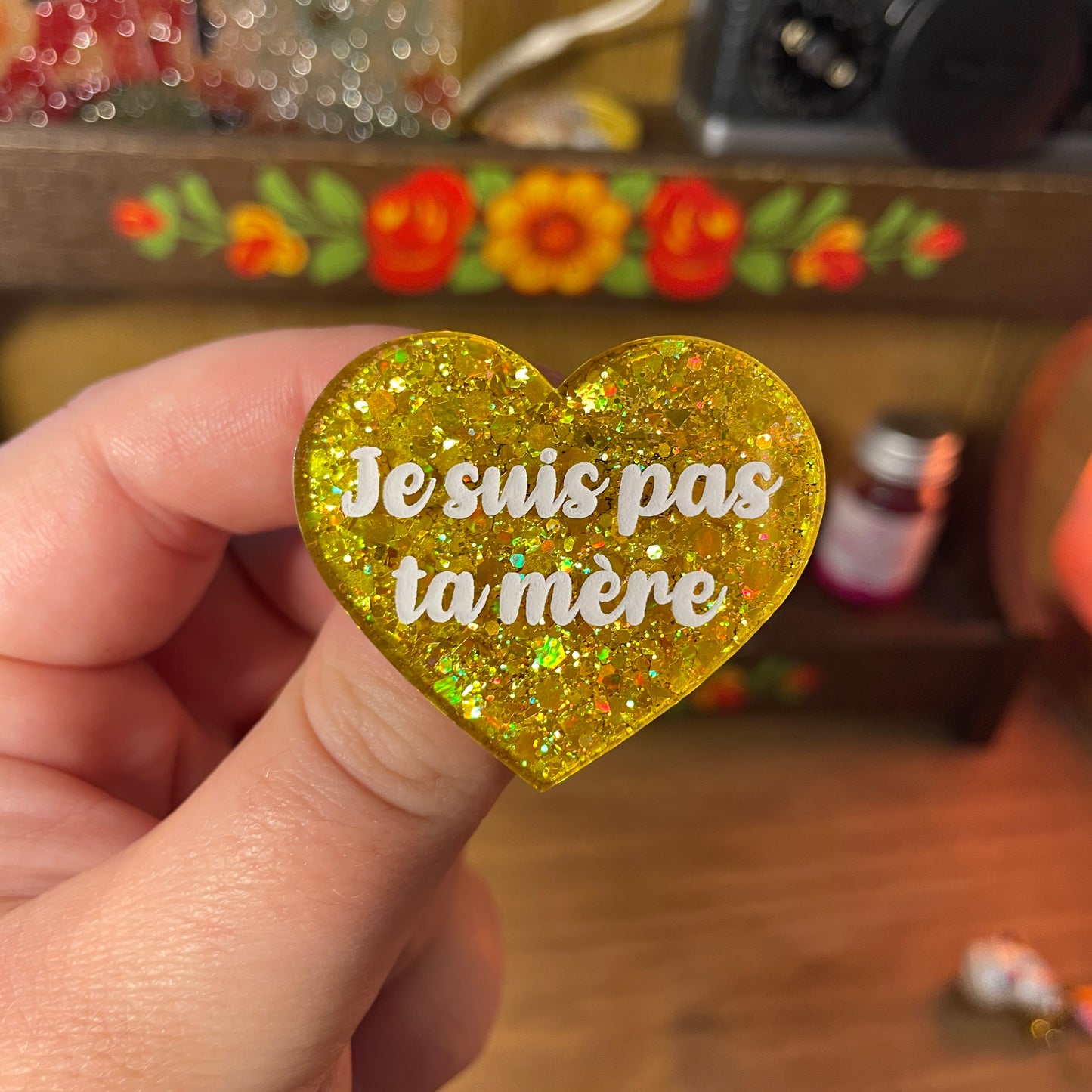 Broche "Je suis pas ta mère" en acrylique semi transparente à paillettes jaunes