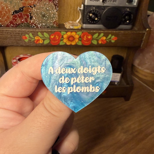 Broche "A deux doigts de péter les plombs" en acrylique marbrée bleue à paillettes