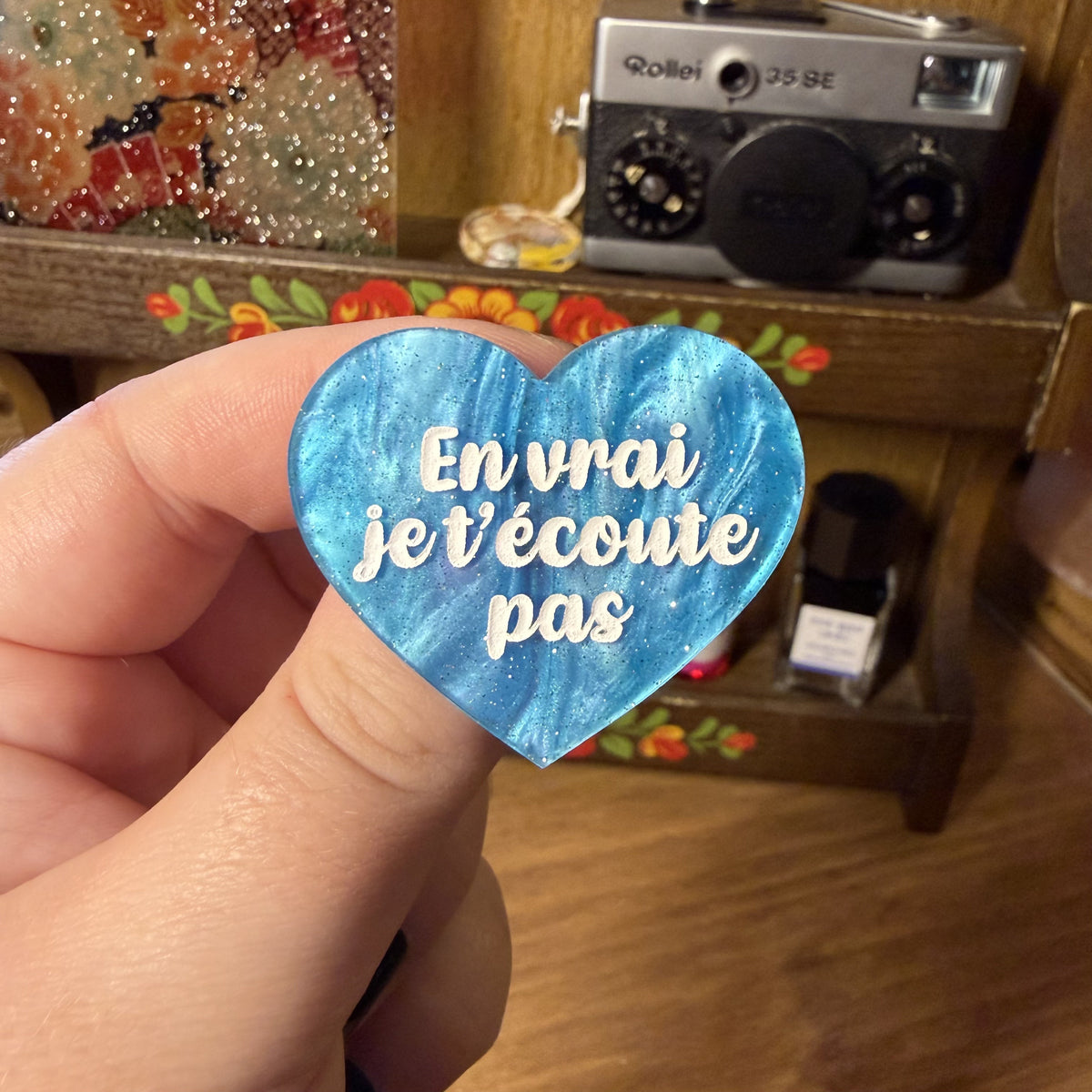 Broche "En vrai je t'écoute pas" en acrylique marbrée bleue à paillettes