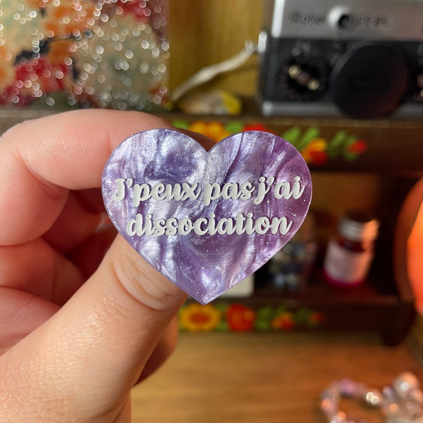 Broche "J'peux pas j'ai dissociation" en acrylique marbrée bleue, blanche et violette à paillettes
