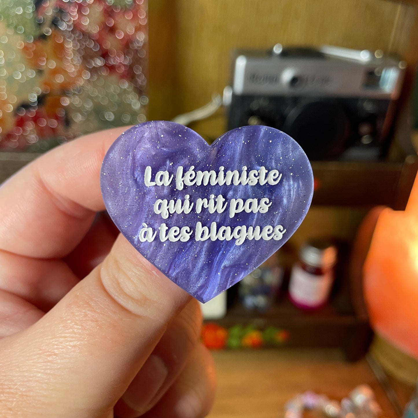 Broche "La féministe qui rit pas à tes blagues" en acrylique marbrée bleue, blanche et violette à paillettes