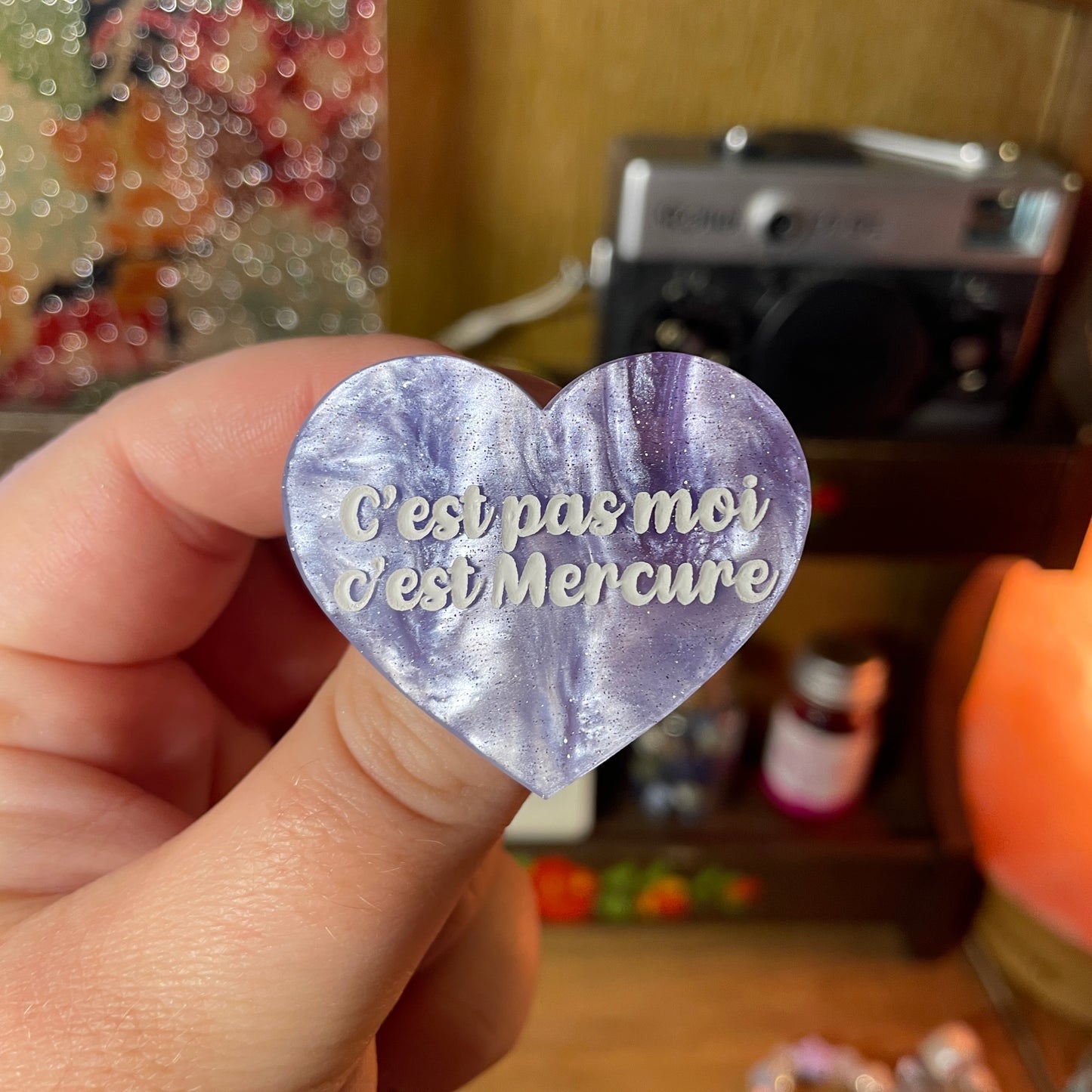 Broche "C'est pas moi c'est Mercure" en acrylique marbrée bleue, blanche et violette à paillettes