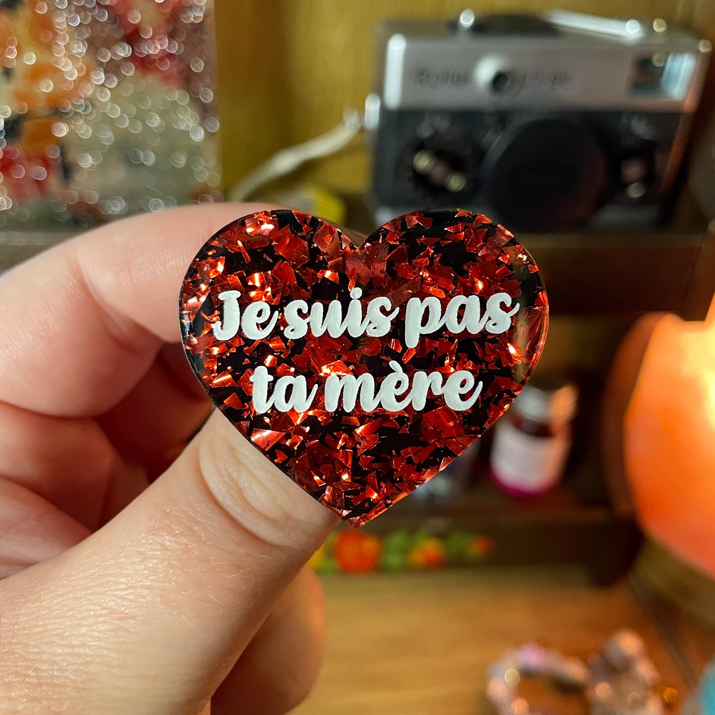 Broche "Je suis pas ta mère" en acrylique noire avec des éclats de confettis rouges