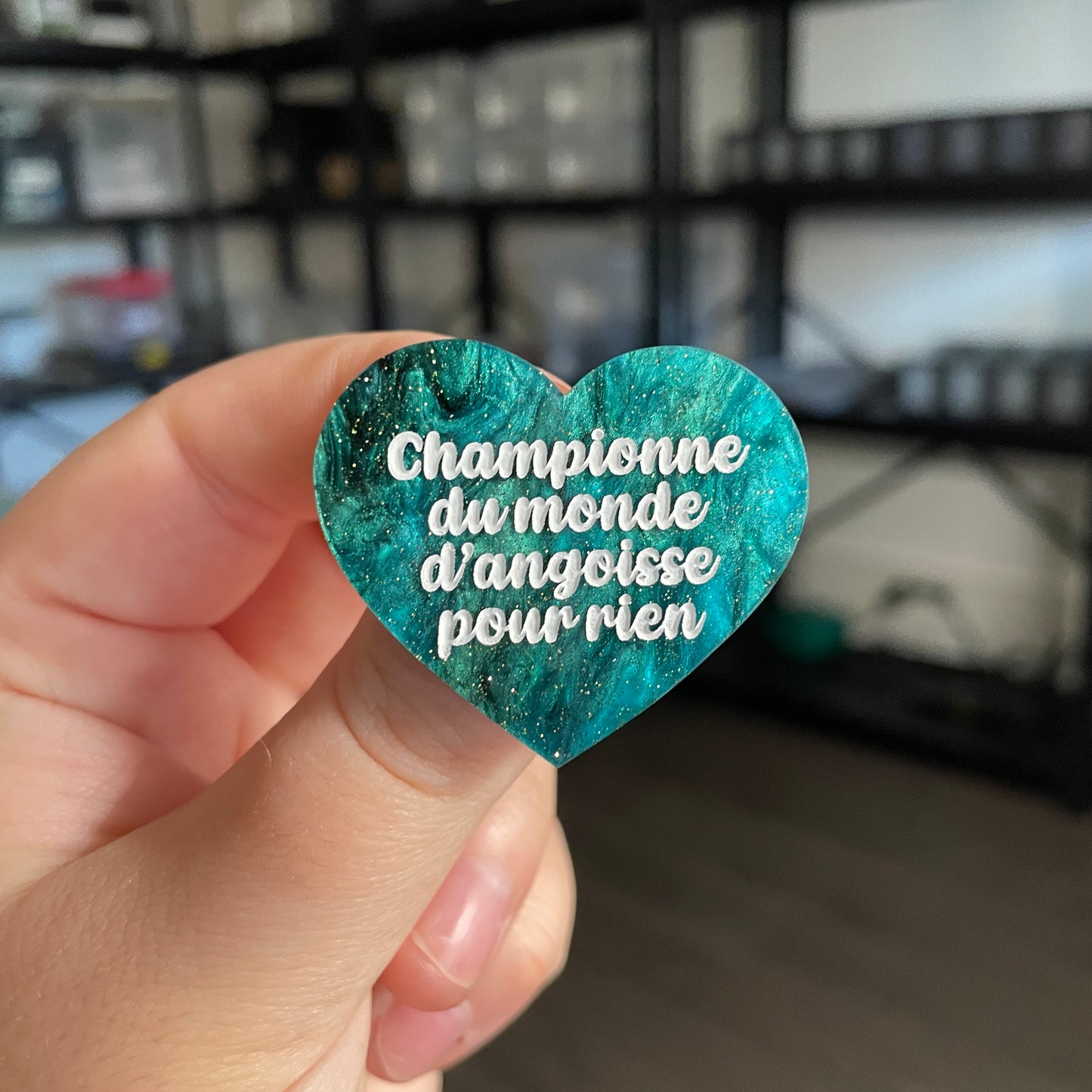 Broche "Championne du monde d'angoisse pour rien" en acrylique marbrée verte et noire à paillettes
