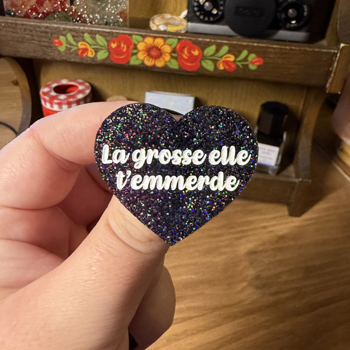 Broche "La grosse elle t'emmerde" en acrylique à paillettes noires holographiques