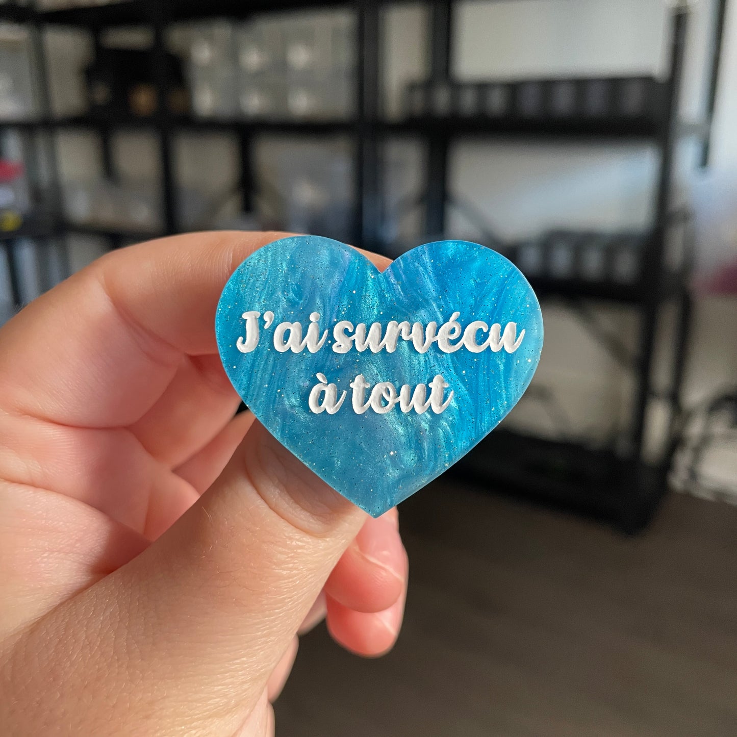 Broche "J'ai survécu à tout" en acrylique marbrée bleue à paillettes