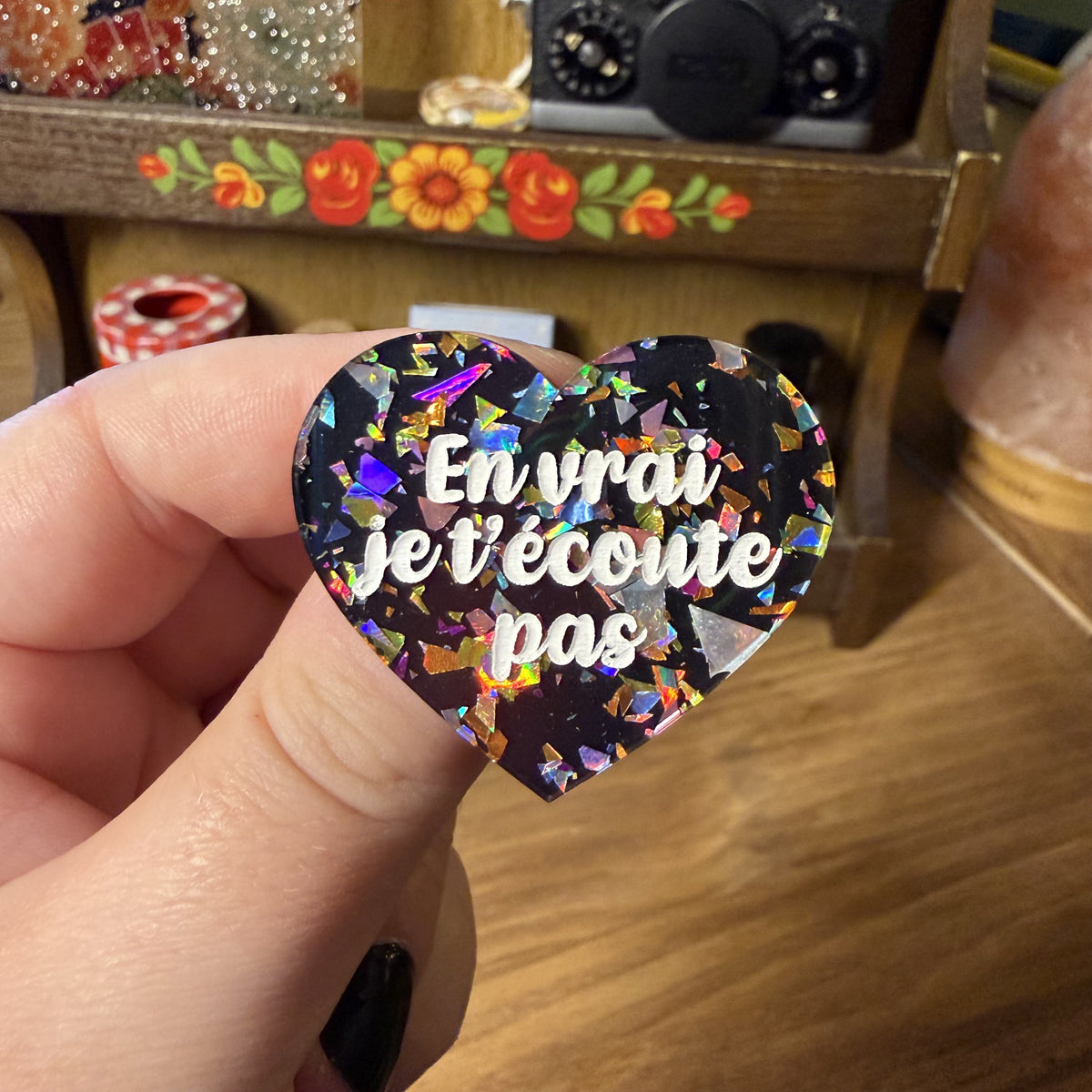 Broche "En vrai je t'écoute pas" en acrylique noire avec des éclats de confettis multicolores