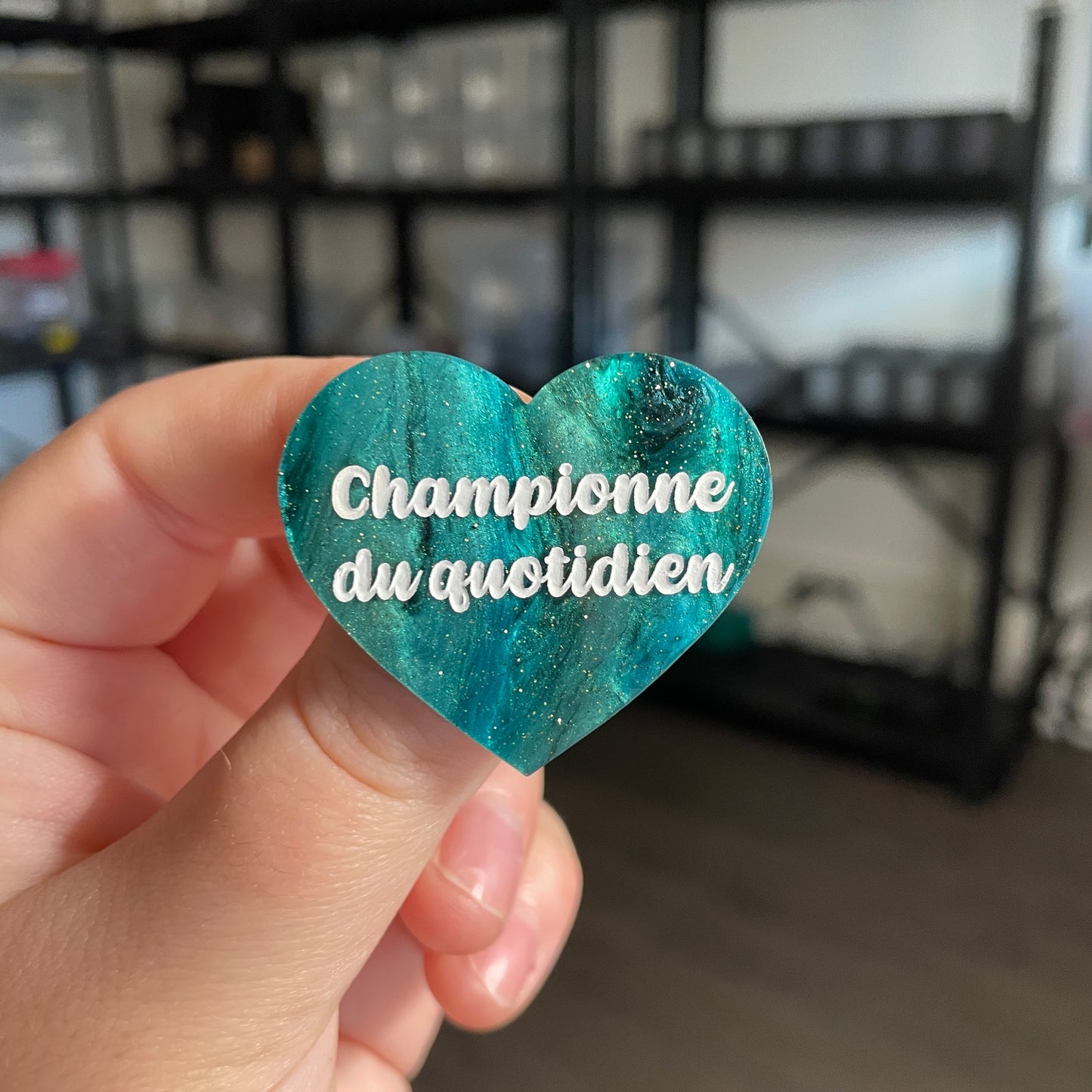 Broche "Championne du quotidien" en acrylique marbrée noire et verte à paillettes