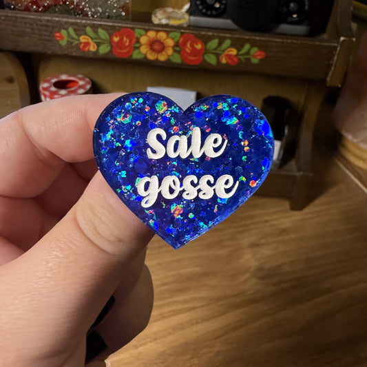 Broche "Sale gosse" en acrylique semi transparente avec des paillettes bleues