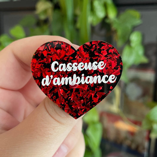 [CONTRÔLE TECHNIQUE] Broche "Casseuse d'ambiance" en acrylique noire avec des éclats de confettis rouges