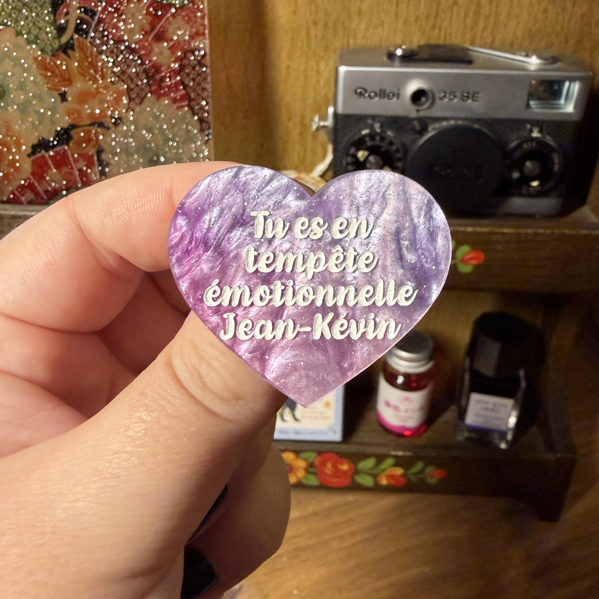 Broche "Tu es en tempête émotionnelle Jean-Kévin" en acrylique marbrée violette, rose et blanche à paillettes