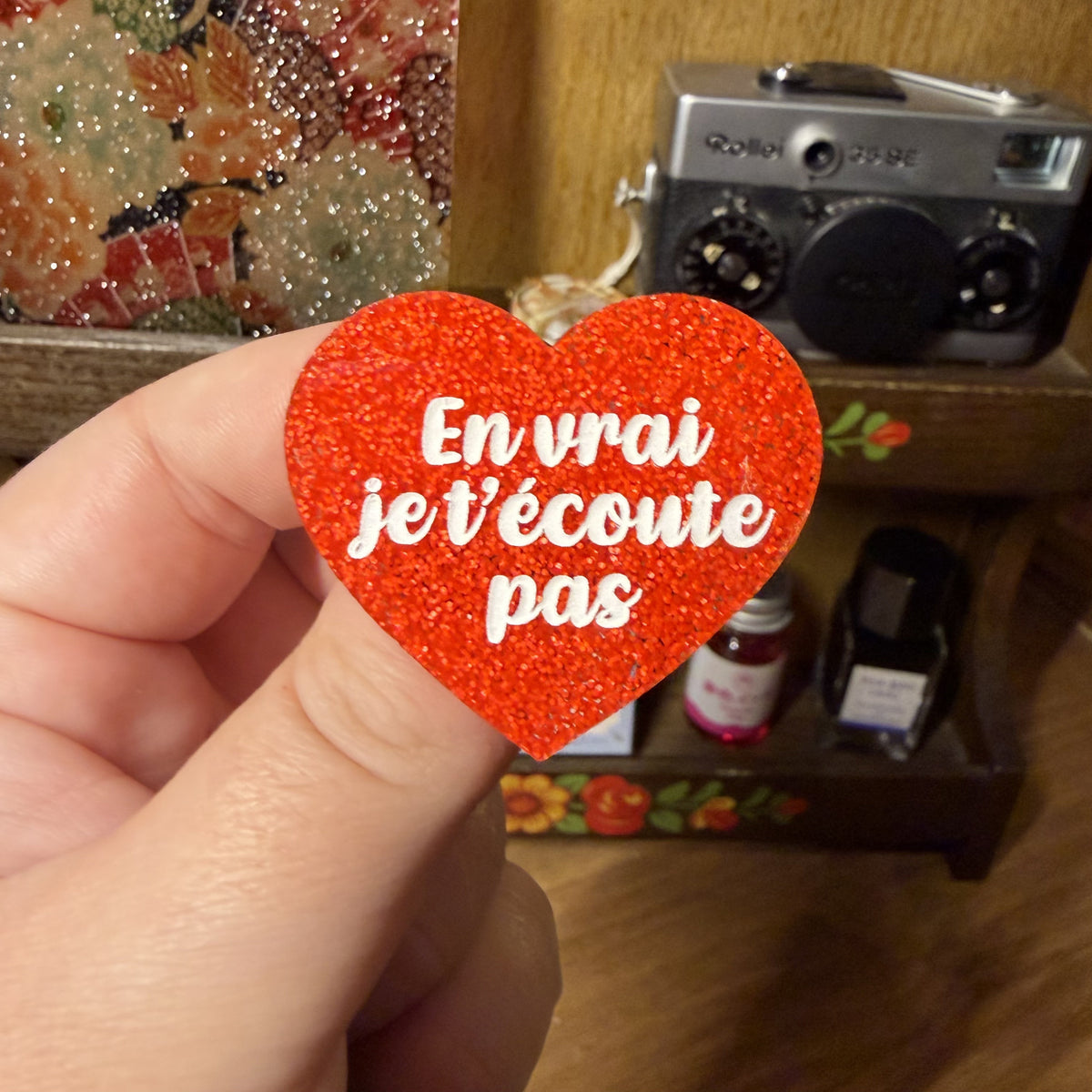 Broche "En vrai je t'écoute pas" en acrylique à paillettes oranges