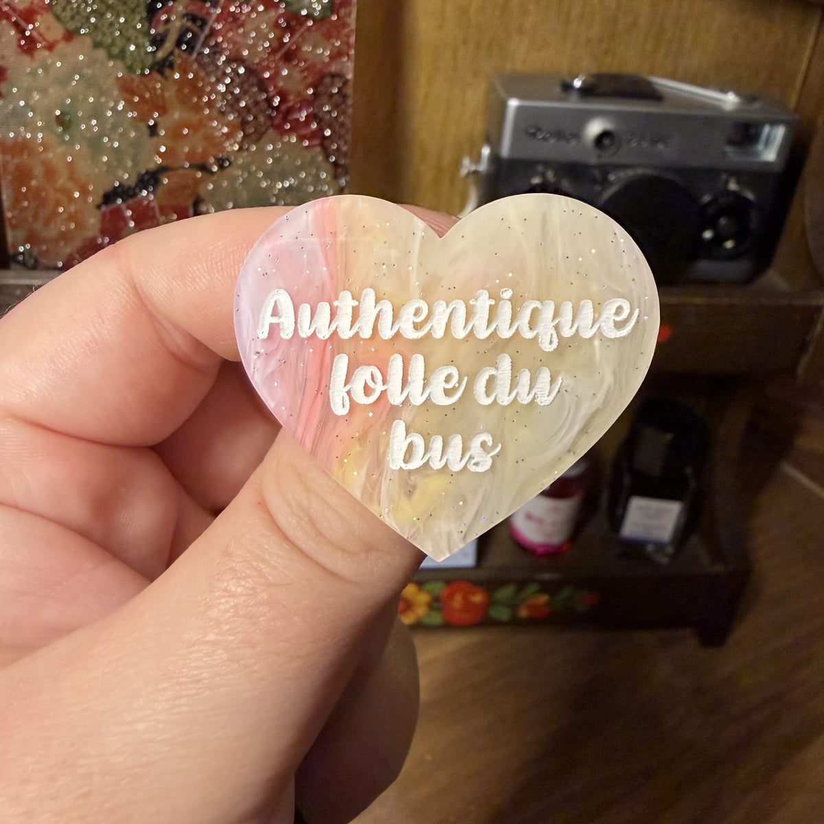Broche "Authentique folle du bus" en acrylique semi transparente marbrée corail, orange et jaune à paillettes