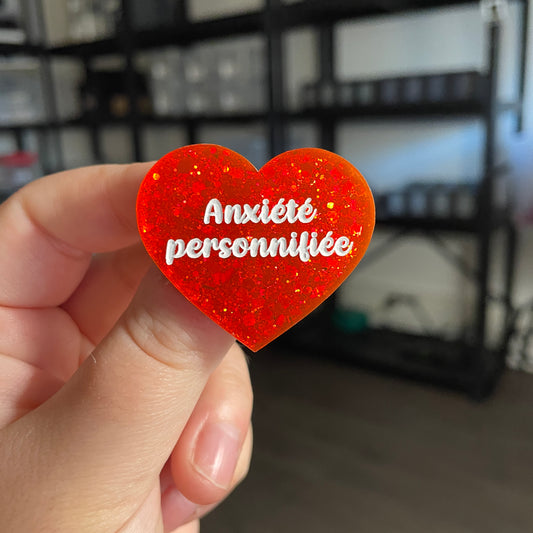 Broche "Anxiété personnifiée" en acrylique à paillettes oranges