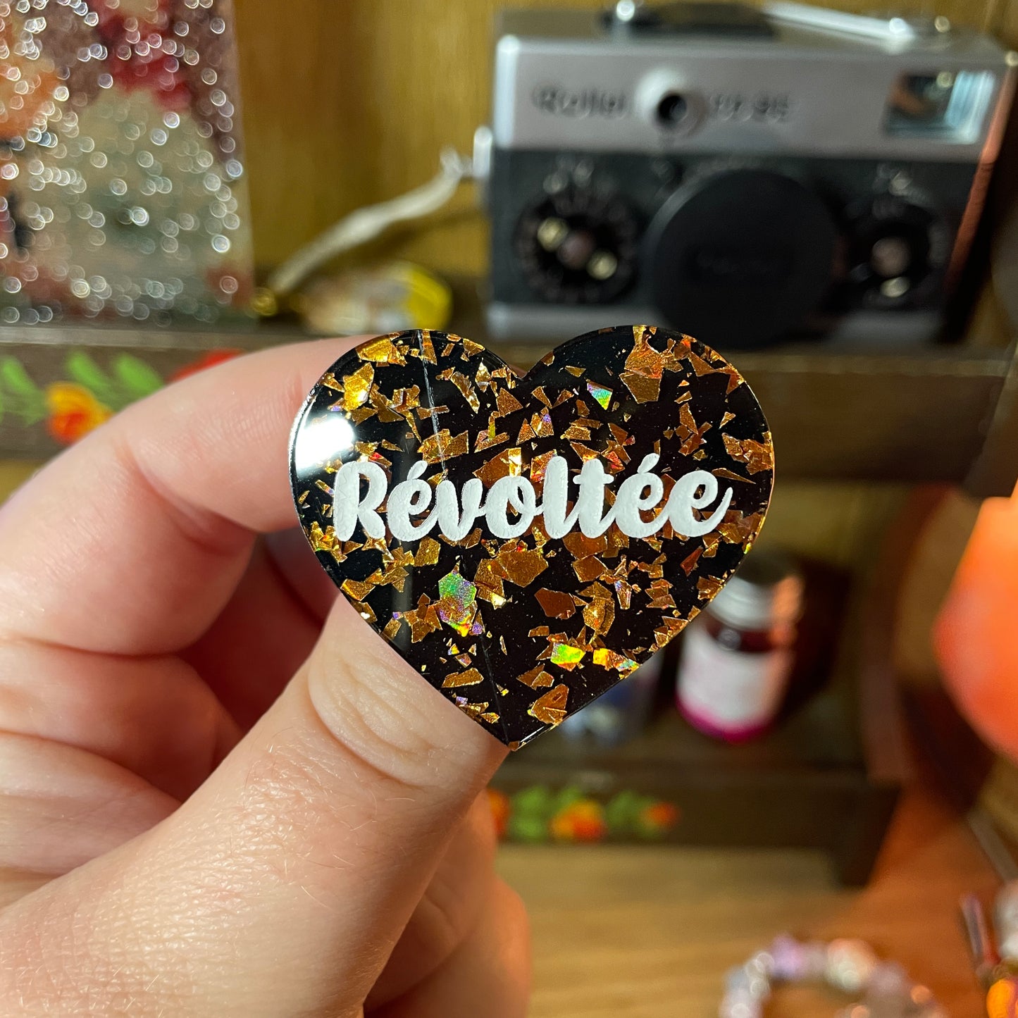 [Contrôle technique] Broche "Révoltée" en acrylique noire avec des éclats de confettis oranges