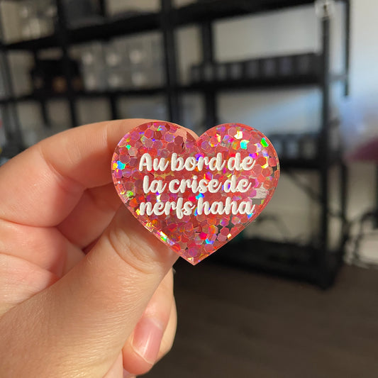 Broche "Au bord de la crise de nerfs haha" en acrylique semi transparente avec des confettis corail
