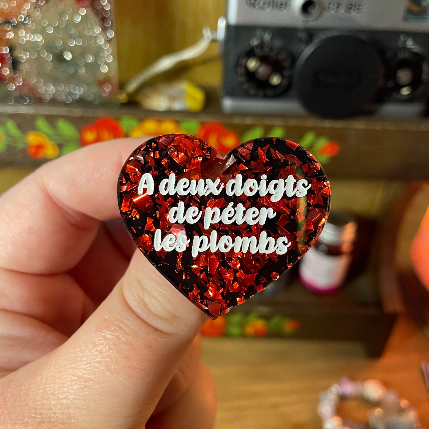 [Contrôle technique] Broche "A deux doigts de péter les plombs" en acrylique noire avec des éclats de confettis violets