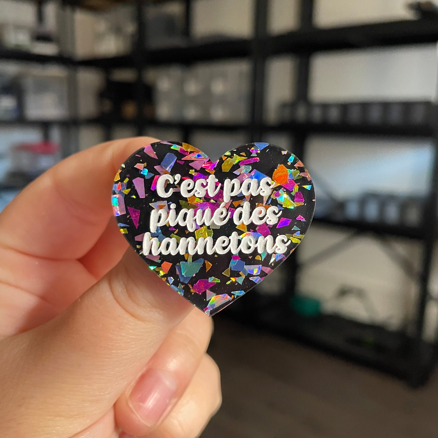 Broche "C'est pas piqué des hannetons" en acrylique marbrée noire avec des éclats de confettis multicolores