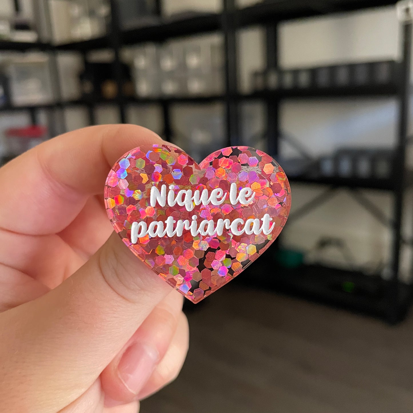 Broche "Nique le patriarcat" en acrylique semi transparente avec des confettis corail