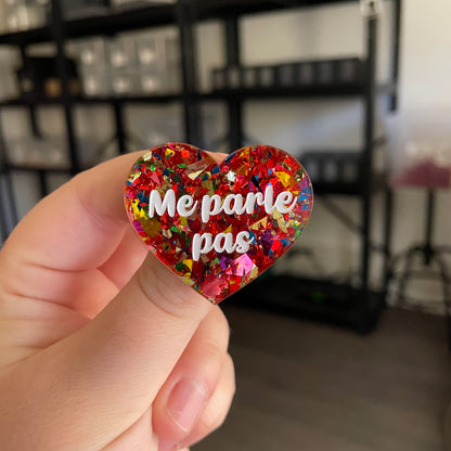 Broche "Me parle pas" en acrylique transparente avec des confettis rouges et multicolores