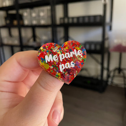 Broche "Me parle pas" en acrylique transparente avec des confettis rouges et multicolores
