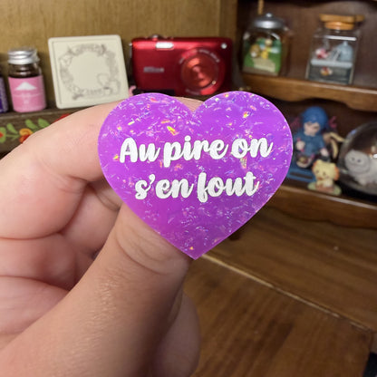Broche "Au pire on s'en fout" en acrylique violette avec des paillettes holographiques