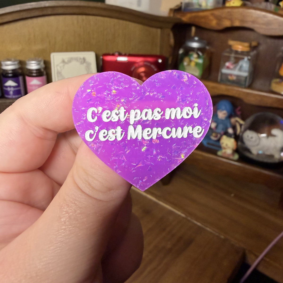 Broche "C'est pas moi c'est mercure" en acrylique violette avec des paillettes holographiques