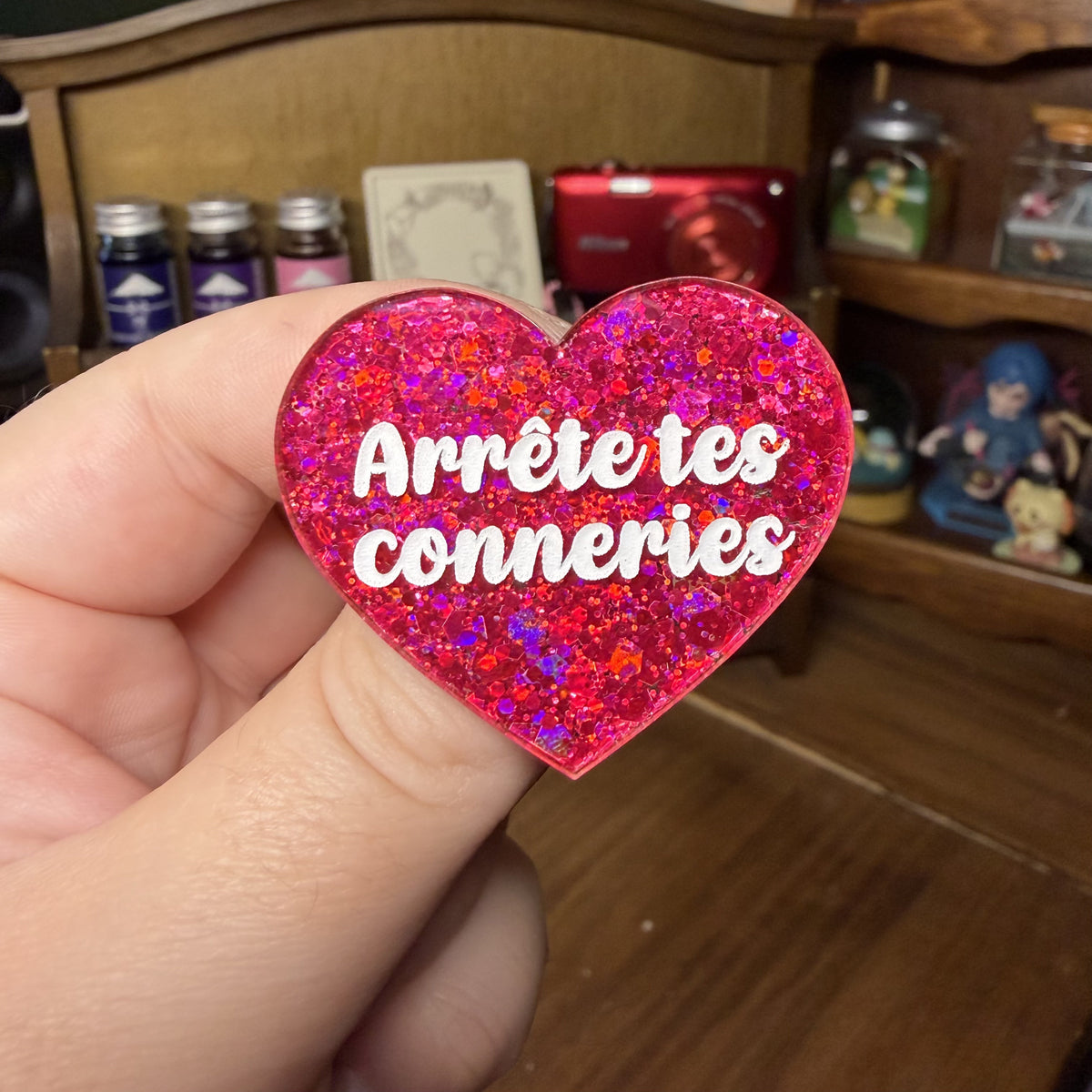 Broche "Arrête tes conneries" en acrylique à paillettes rouges