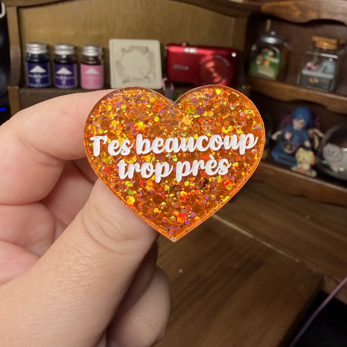 Broche "T'es beaucoup trop près" en acrylique à paillettes oranges