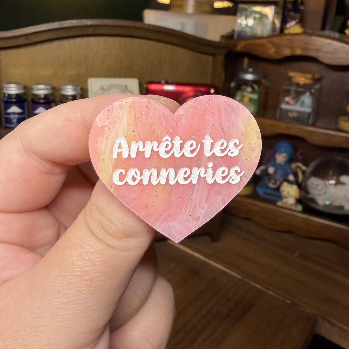Broche "Arrête tes conneries" en acrylique marbrée corail, jaune et blanche à paillettes