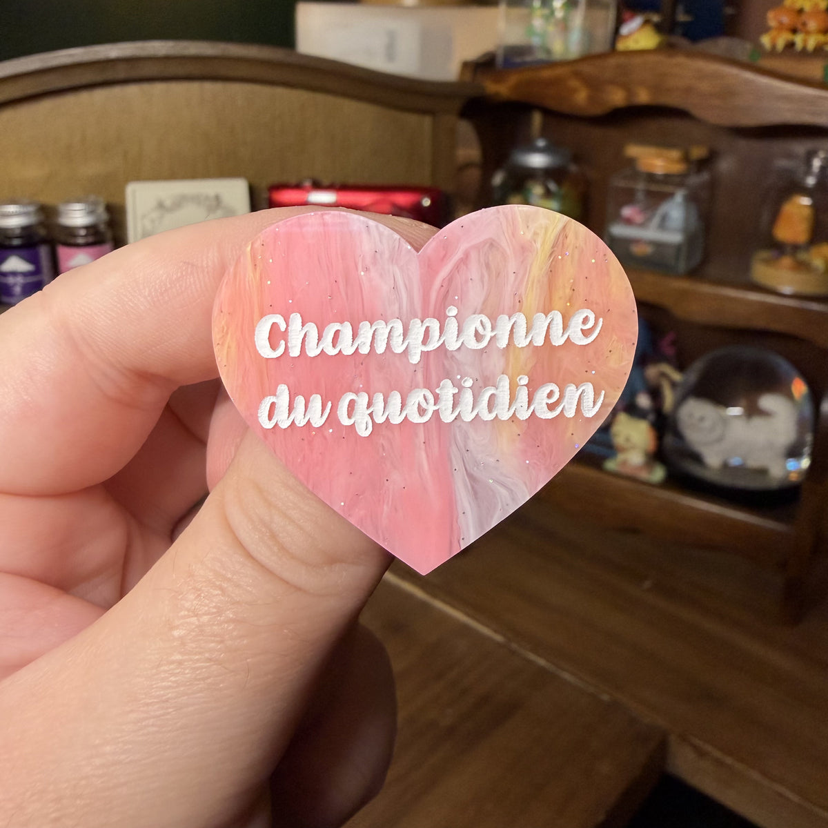 Broche "Championne du quotidien" en acrylique marbrée corail, jaune et blanche à paillettes