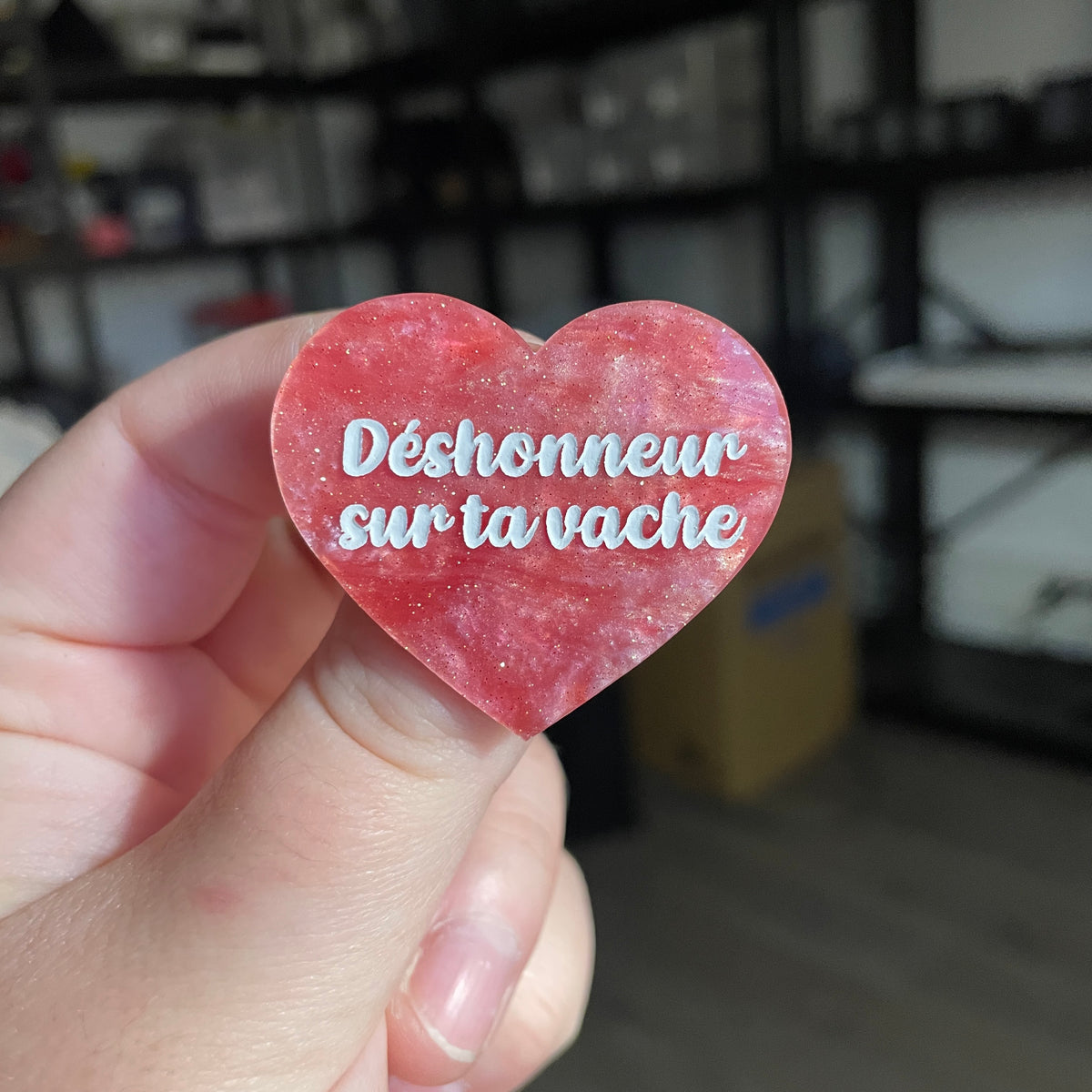 Broche "Déshonneur sur ta vache" en acrylique marbrée rose à paillettes
